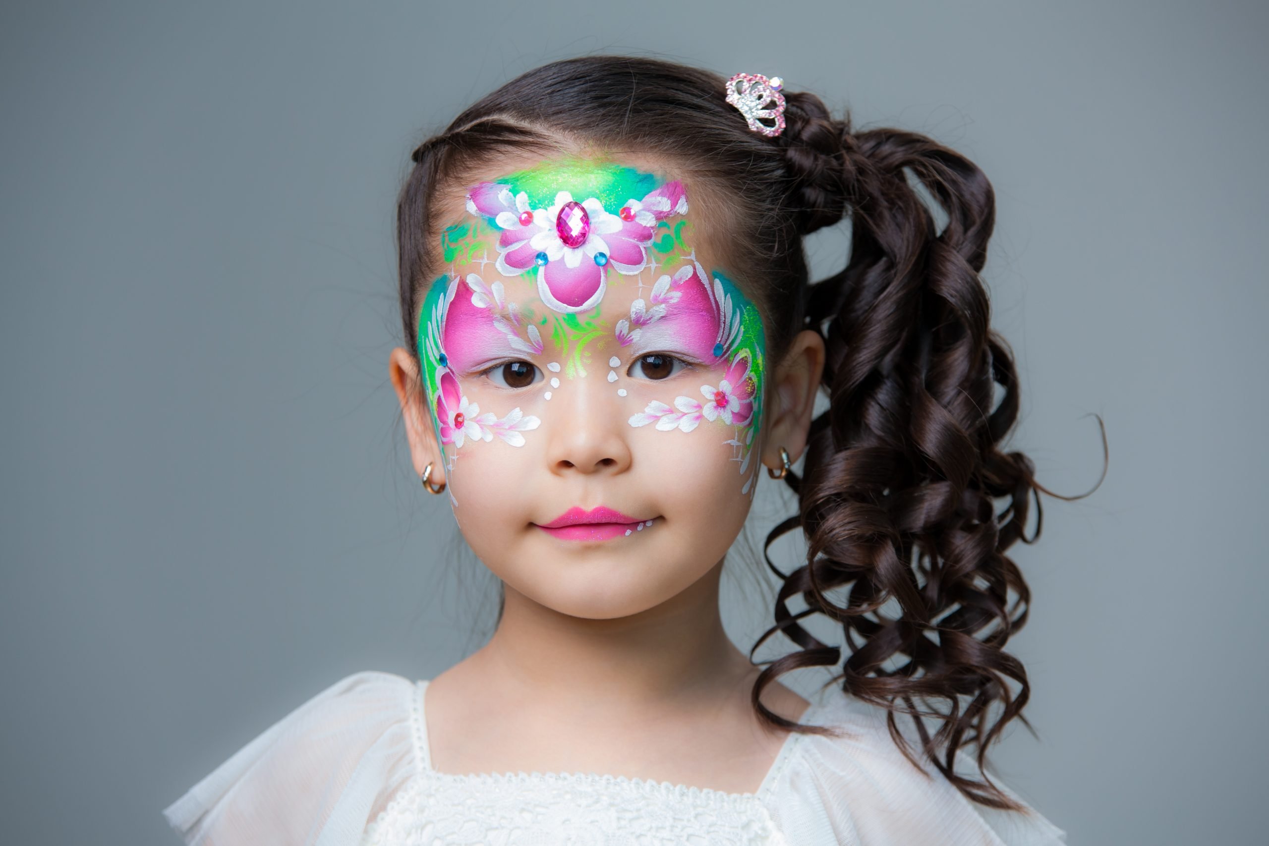 Pretty face painting with purple and green flowers